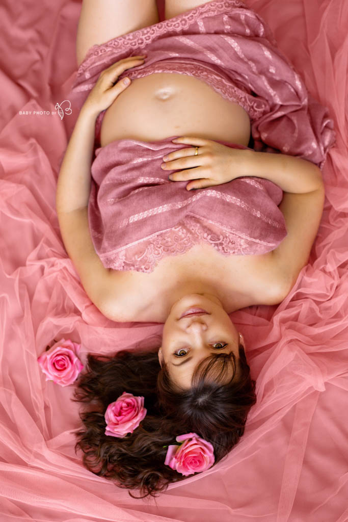 pregnant lady laying in pink fabric